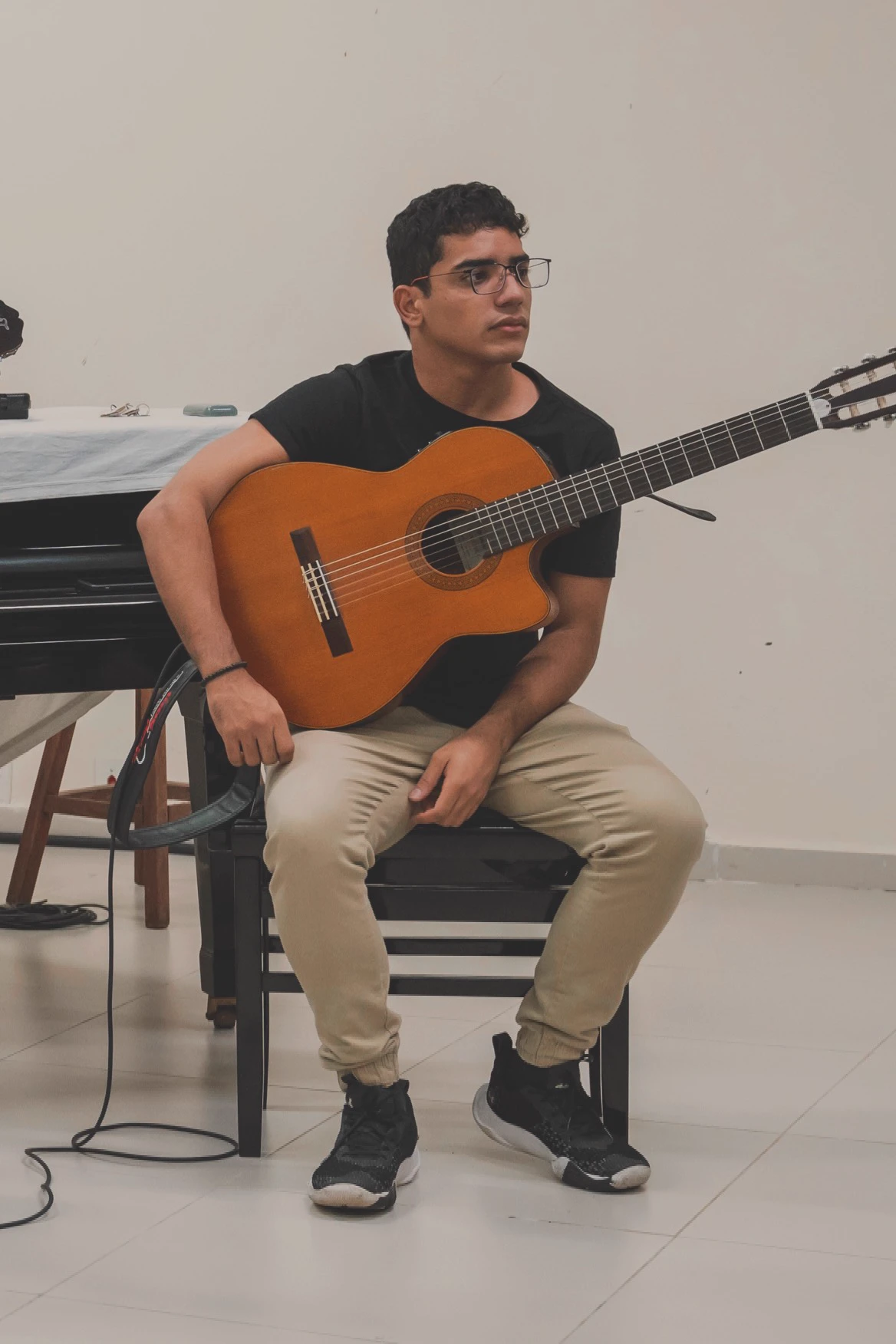 Aderval sentado com o violão